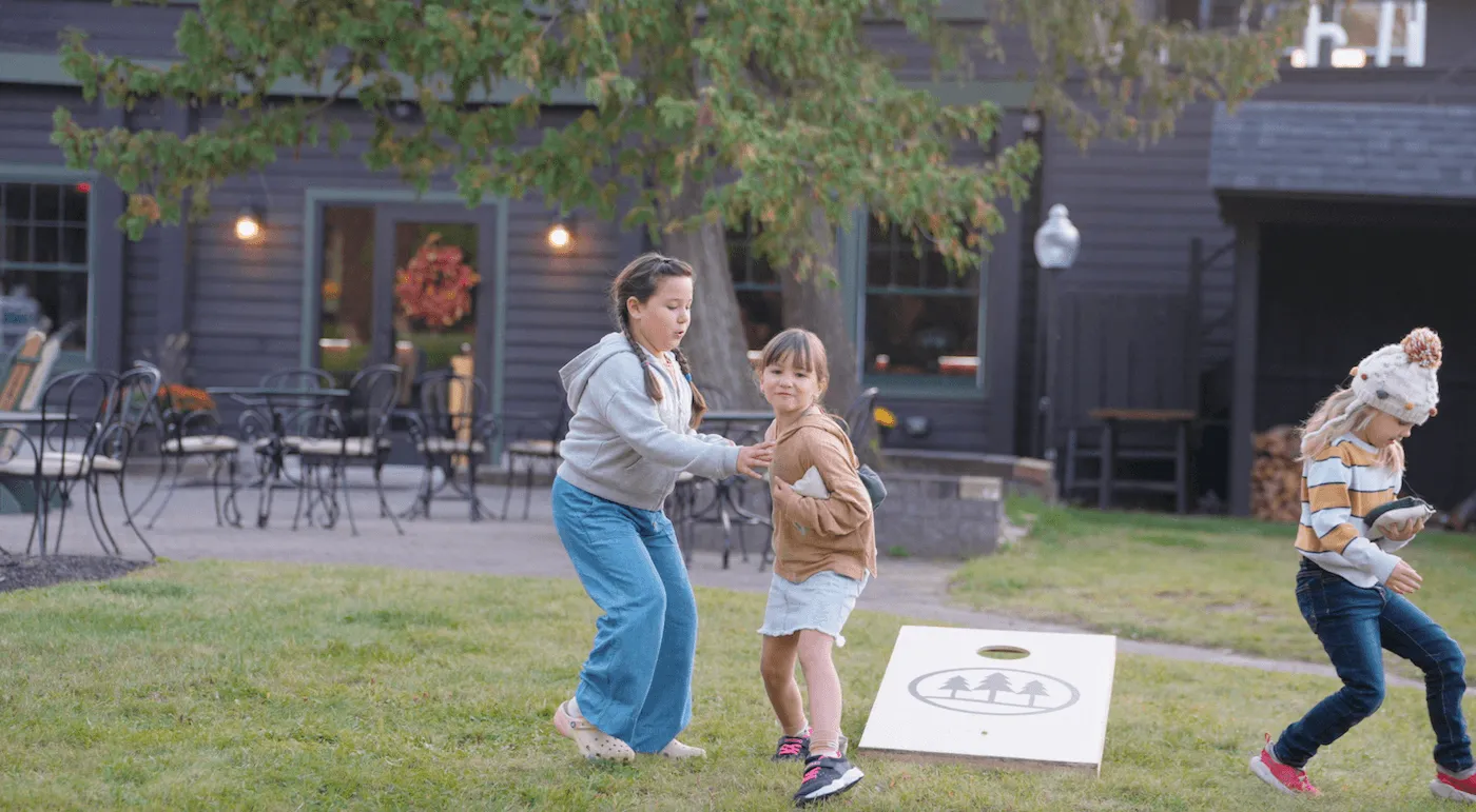 Kids Playing Bean Bag Toss On The Lawn
